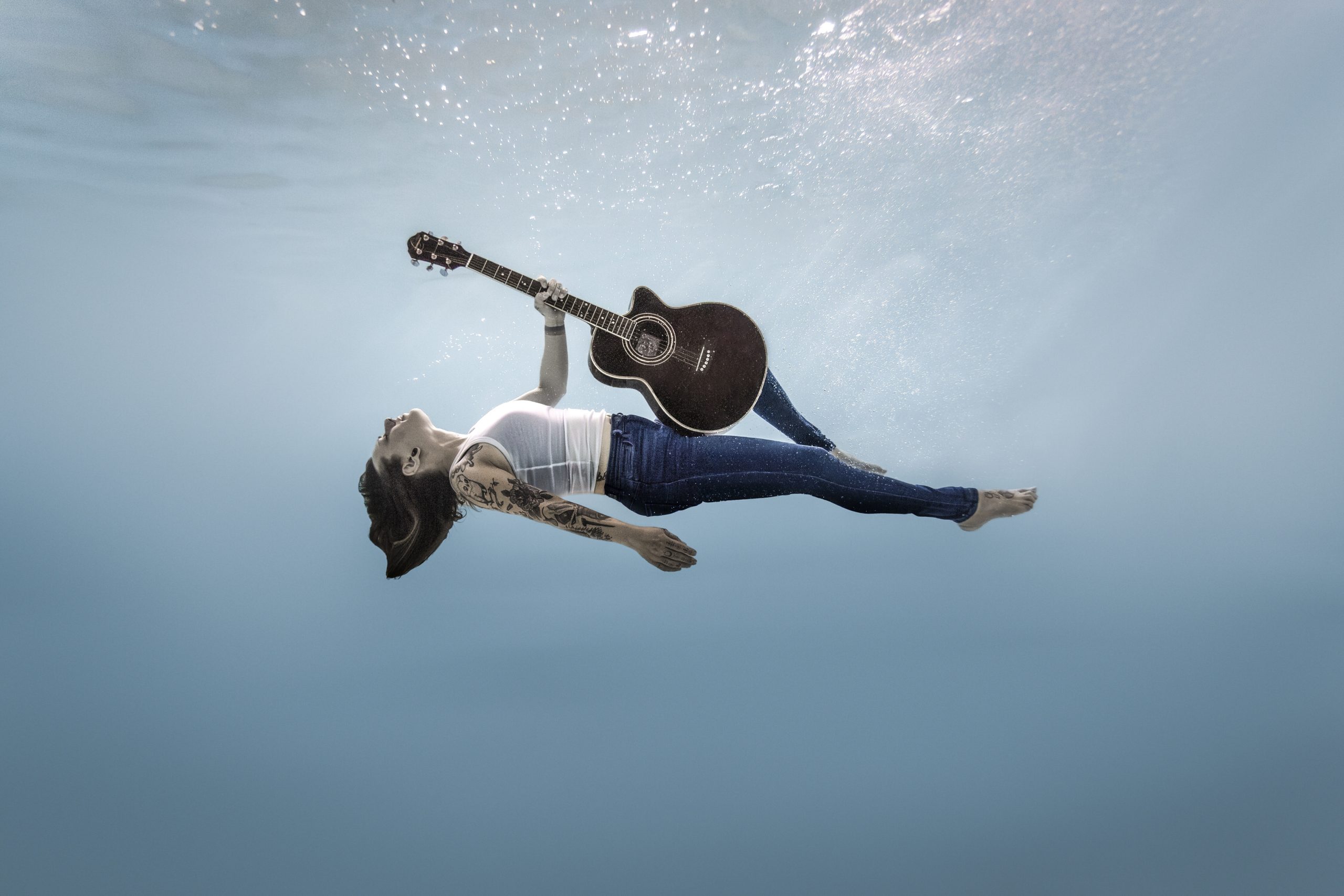 Photographie aquatique musicienne en piscine – séance photo à Nantes avec une guitare