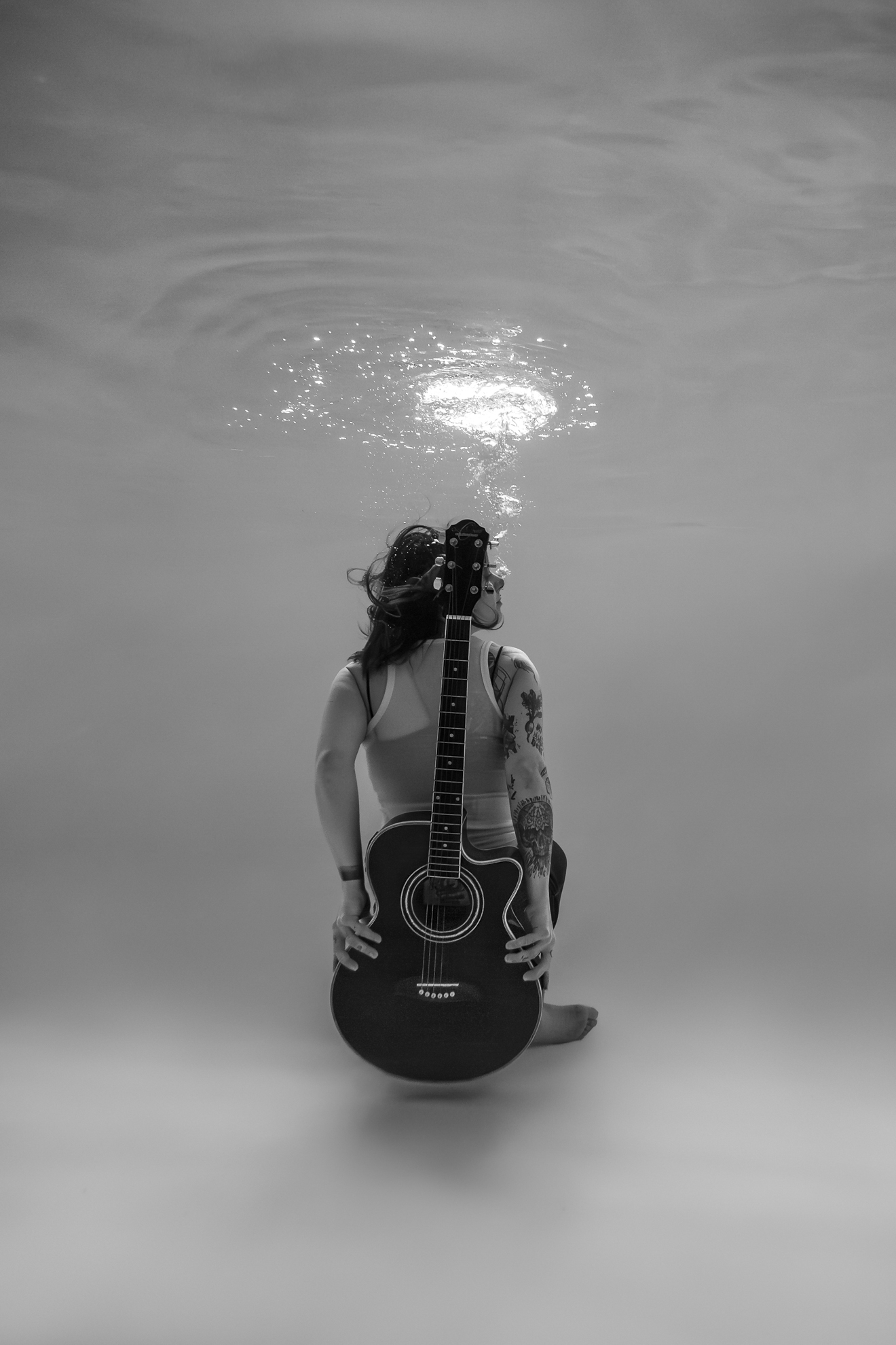 Femme musicienne sous l’eau avec guitare dans une création artistique en photographie aquatique à Nantes