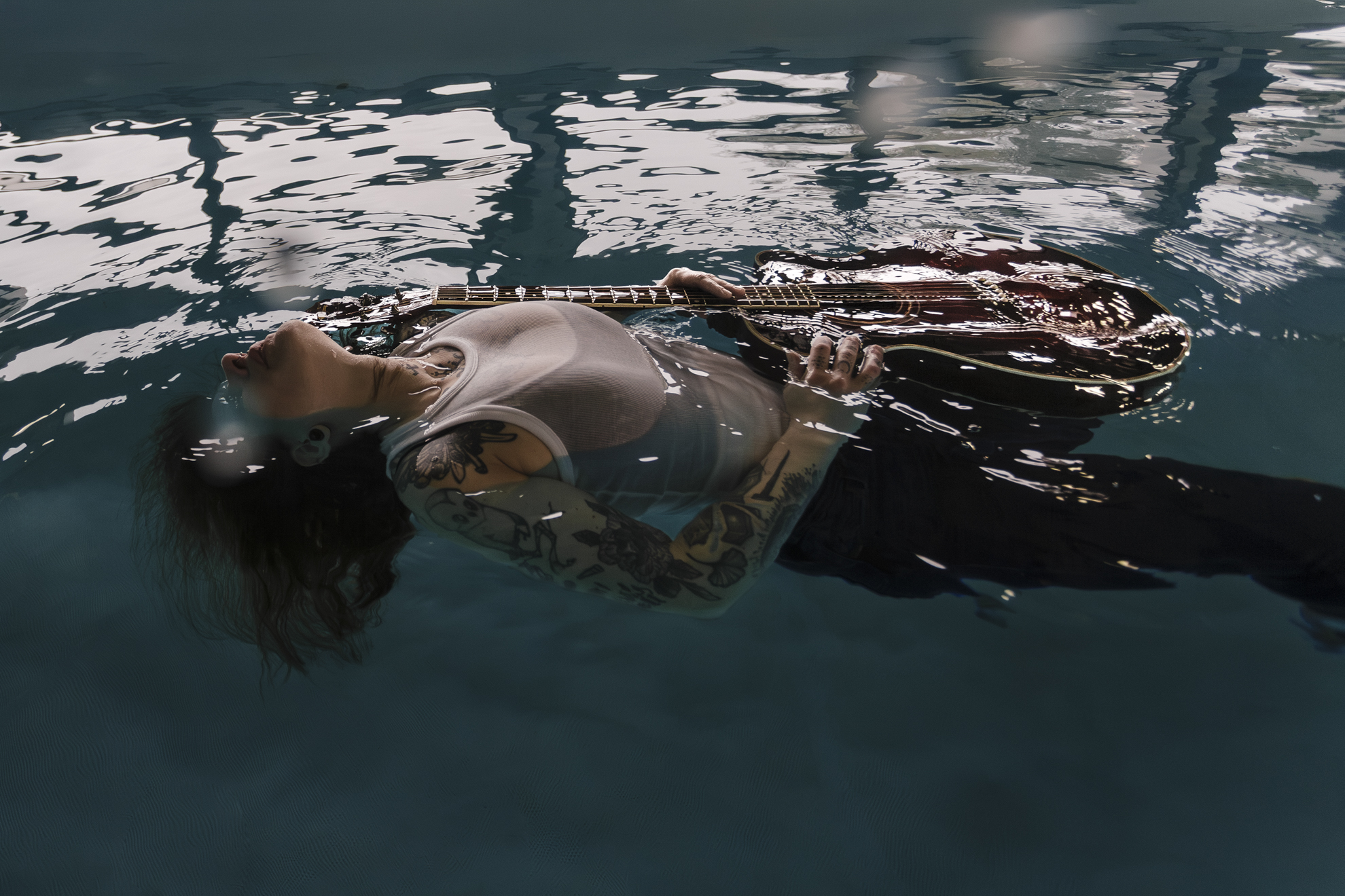 Femme musicienne sur l’eau avec guitare dans une création artistique en photographie aquatique à Nantes