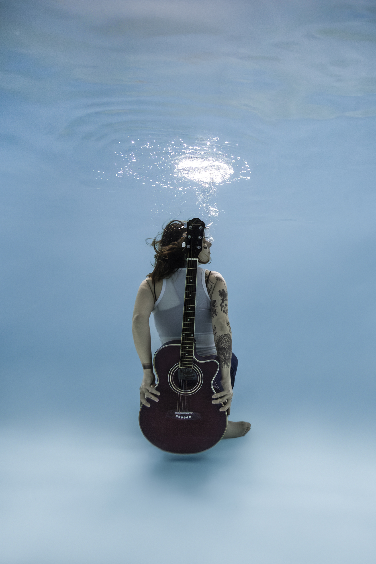 Portrait aquatique artistique d’une femme avec une guitare sous l’eau à Nantes
