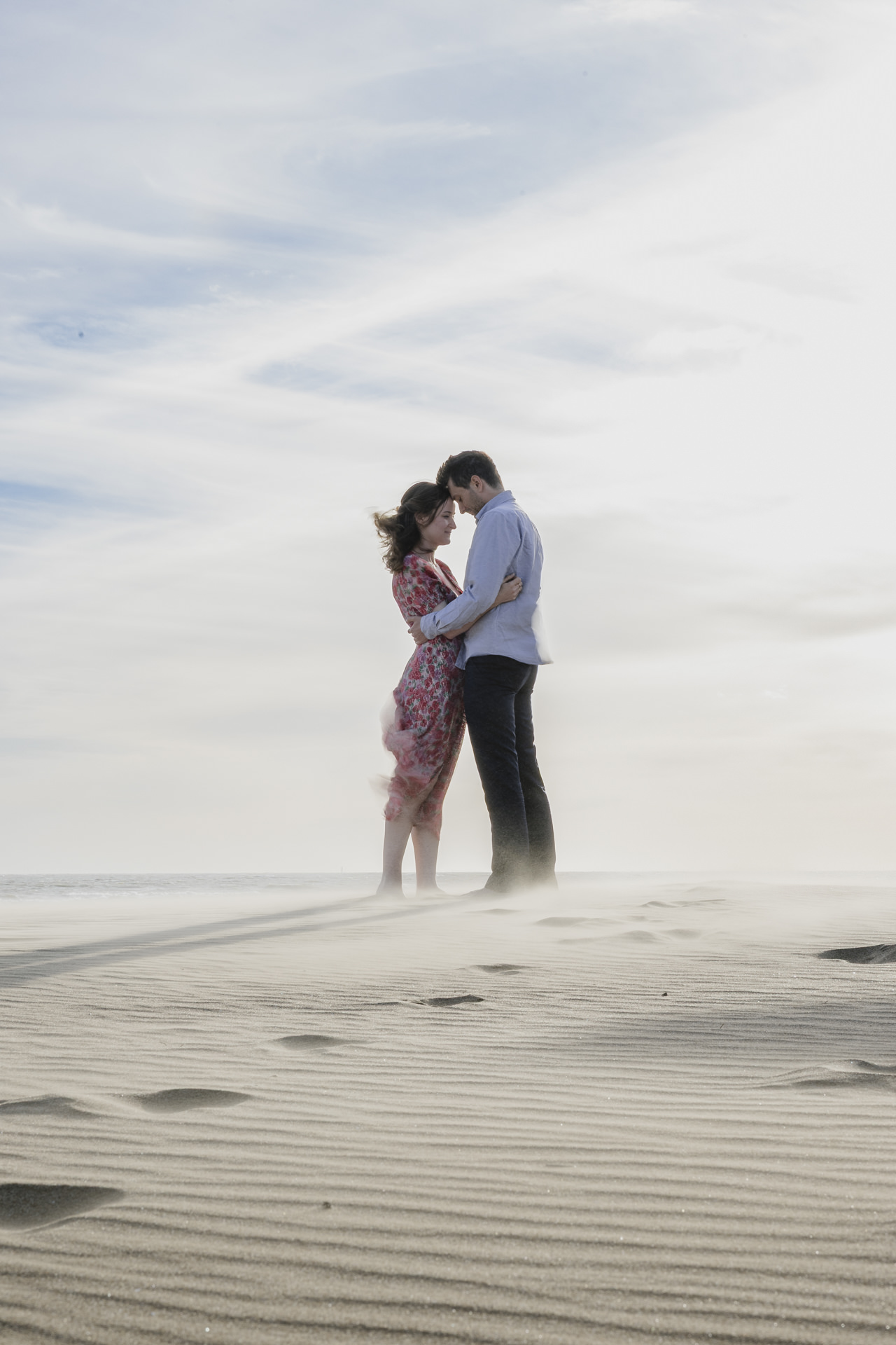 Couple sur la plage avec sable en suspension et ambiance unique